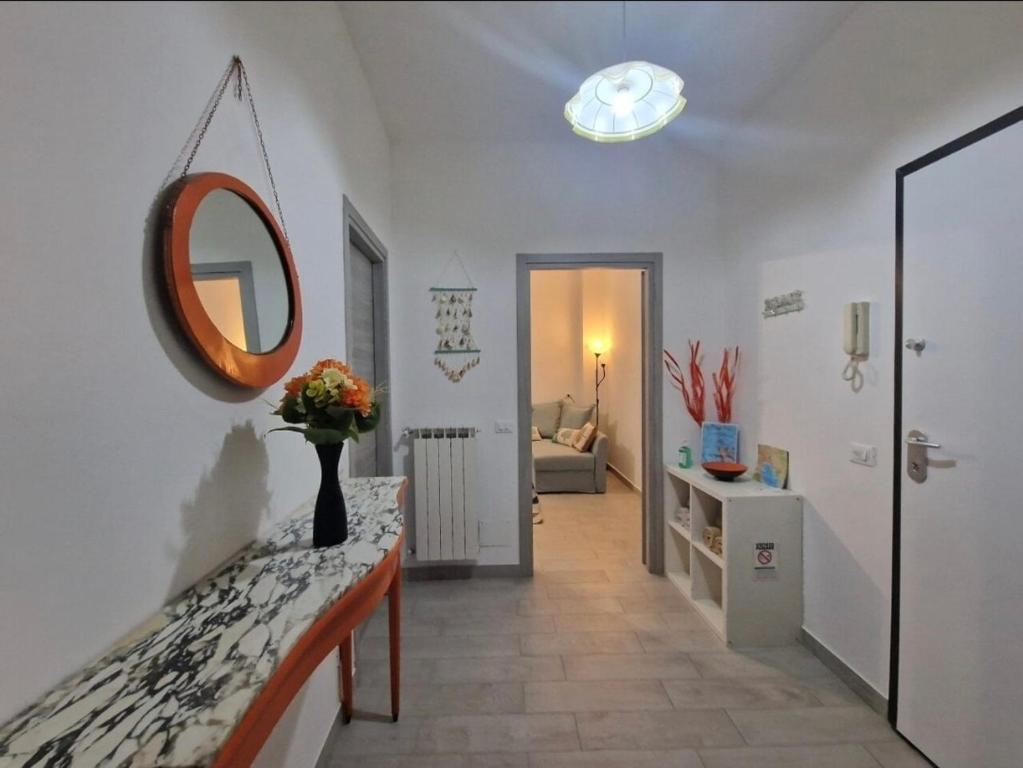 a hallway with a mirror and a vase of flowers on a counter at Appartamento Denis in Rapallo