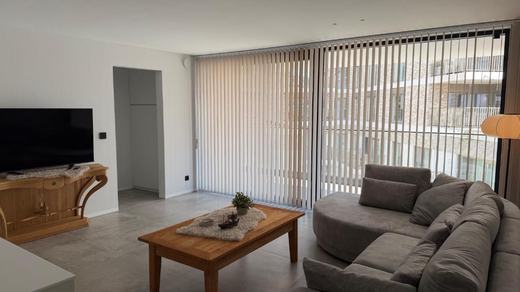 a living room with a couch and a table at The 996 Business Flat in Lommel