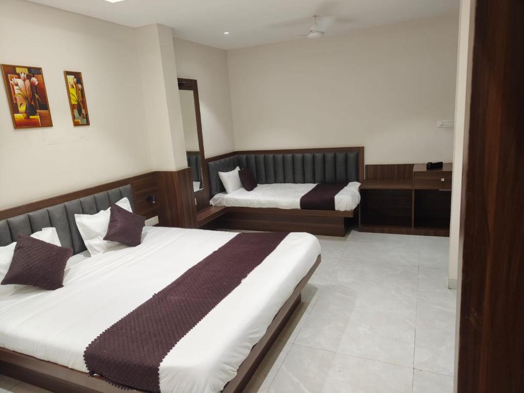 a hotel room with two beds in a room at Hotel Bhasmaarti Ujjain in Ujjain