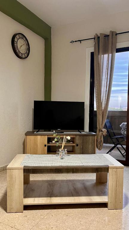 a living room with a coffee table and a tv at Forty Columns flat in Paphos