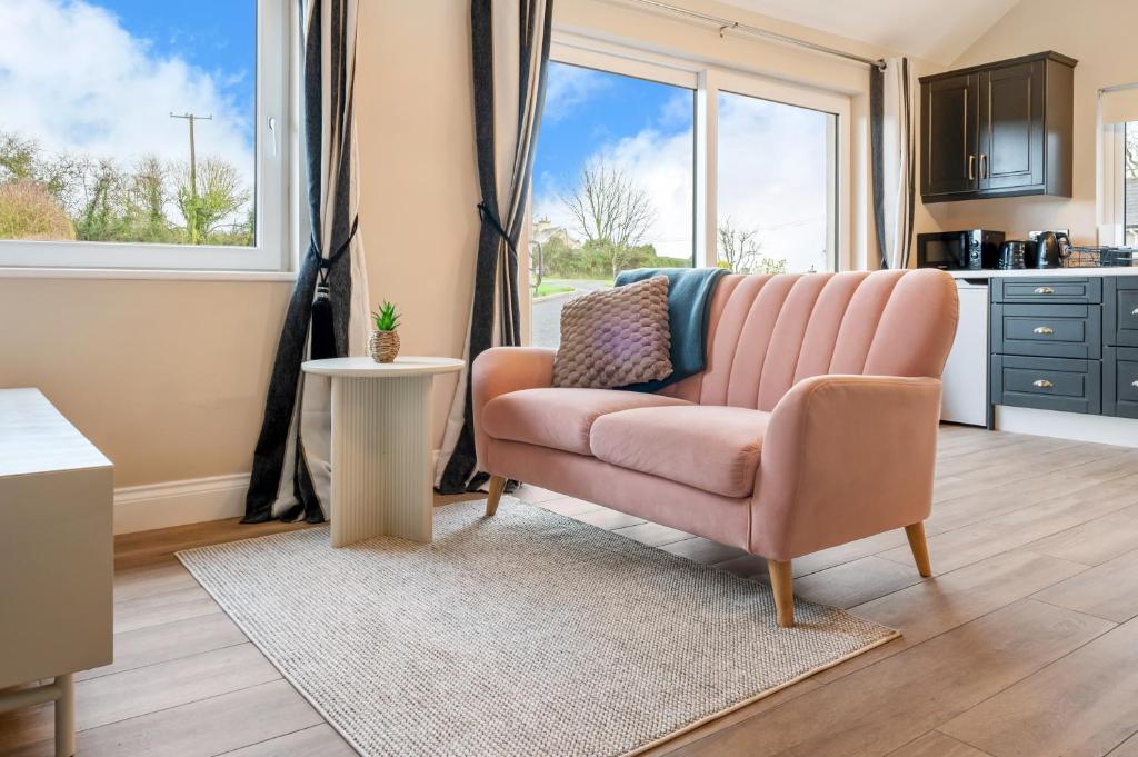 a living room with a pink couch and a window at The Meadows at Marlhill in Tipperary