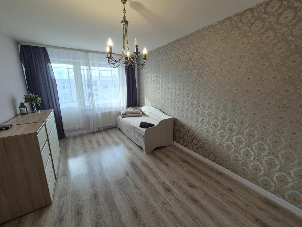 a bedroom with a dog bed in the corner of a room at Butas in Mažeikiai