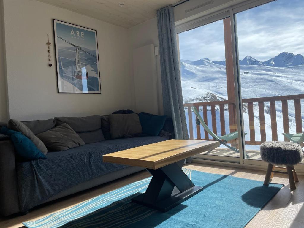 a living room with a couch and a table and a window at T3cab-Peyragudes-61m2-8pers in Germ