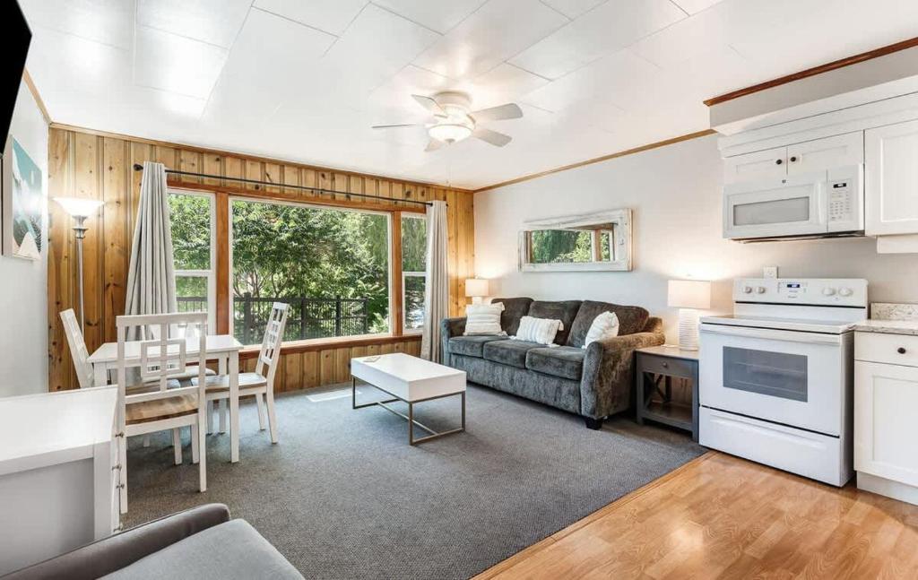 a kitchen and living room with a couch and a table at Ground Floor Riverside Cottage with Patio in Bend