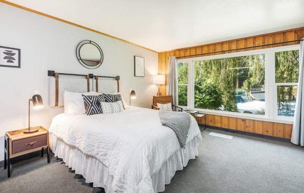 a bedroom with a bed and a large window at Pet Friendly Riverside Studio in Downtown Bend in Bend