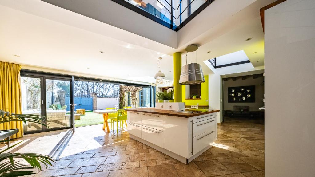 a kitchen with yellow walls and a ceiling with windows at Maison ALMA Piscine -Baby Foot - Cheminée- Jacuzzi in Vantoux