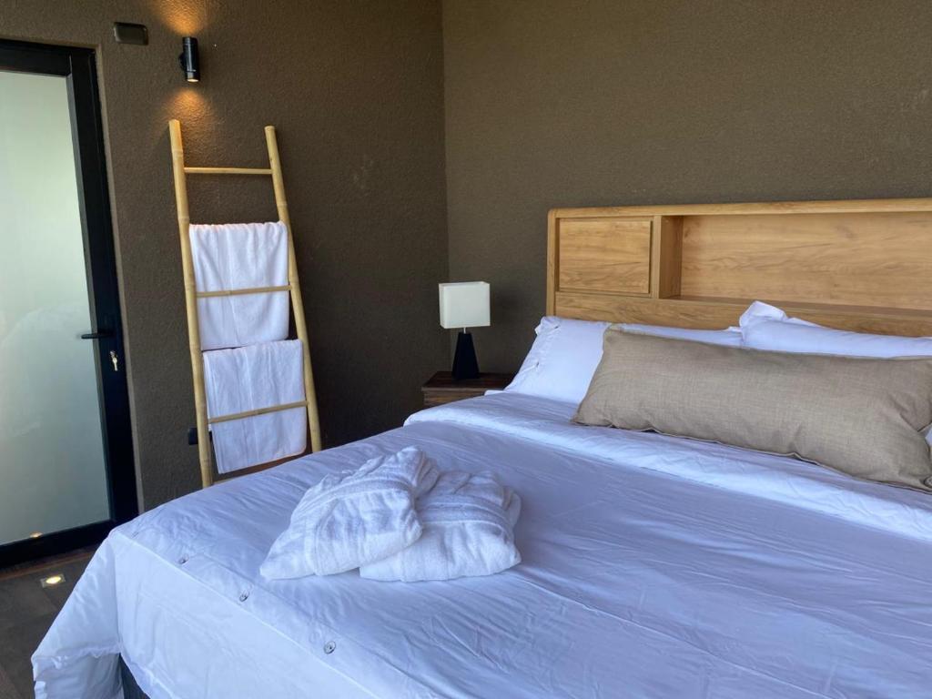 a bedroom with a bed with two pillows on it at Apalta Vista Wine Lodge in Estación Santa Cruz