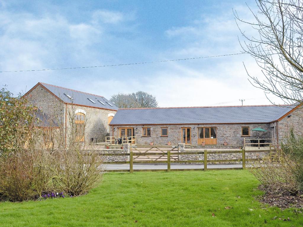 a brick barn with a fence in front of it at The Parlour - Op4 in Carmarthen