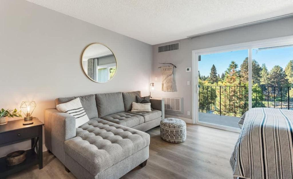 a living room with a couch and a large window at Updated Condo with Deschutes River View in Bend