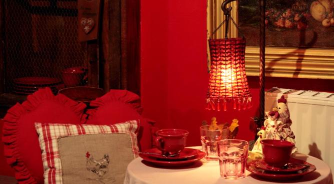 een rode kamer met een tafel met een tafel sidx sidx sidx bij Gîte Maison des Vignerons in Riquewihr