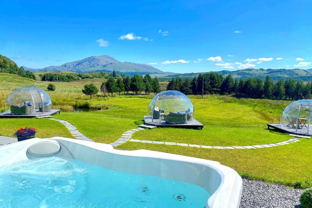 a hot tub in a field with two domes at Mingarry Park in Acharacle