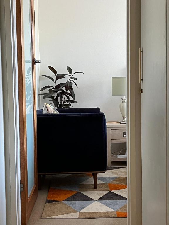 a living room with a chair and a plant at Campbell comfort and convenience in Campbell