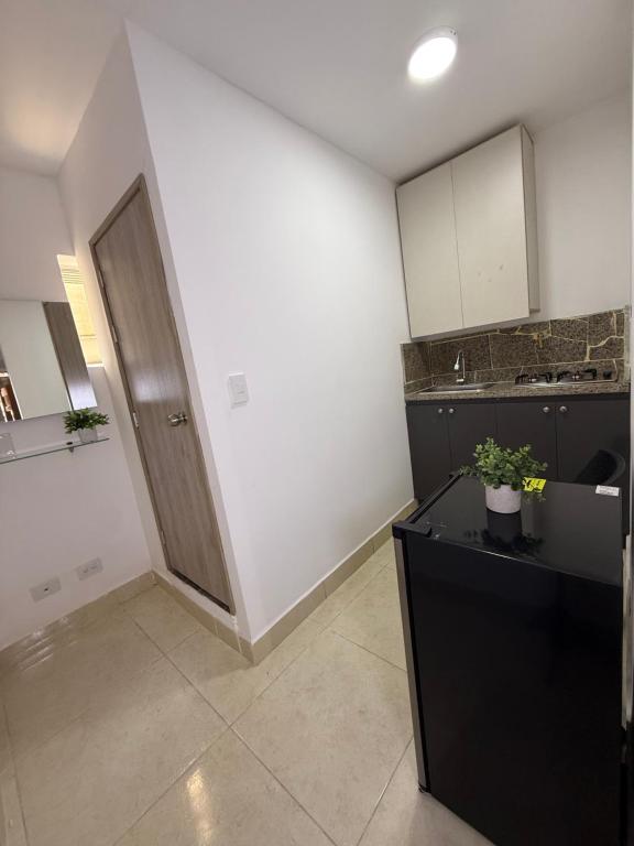 a kitchen with a black counter and a door at Apartaestudio grupal privado dentro de hotel in Medellín