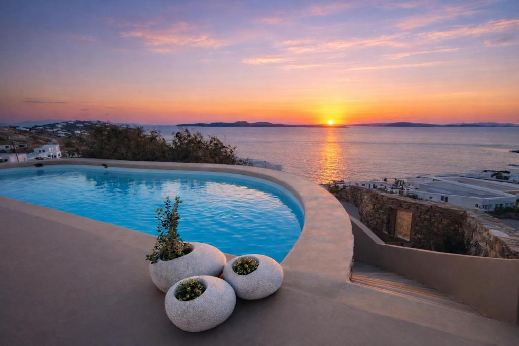 a swimming pool with a view of the ocean at sunset at Villa Vanita Agios Ioannis Mykonos in Agios Ioannis Mykonos