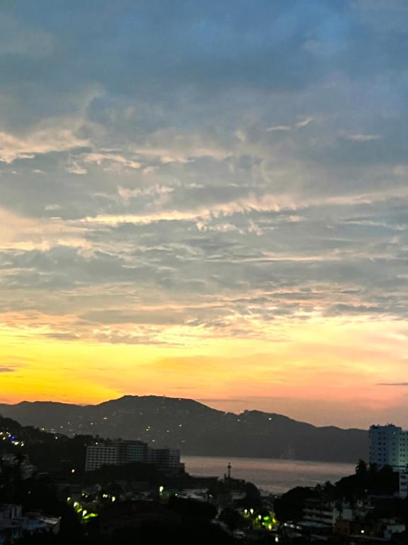 a view of a city with a sunset at Departamento en Acapulco Caleta in Acapulco