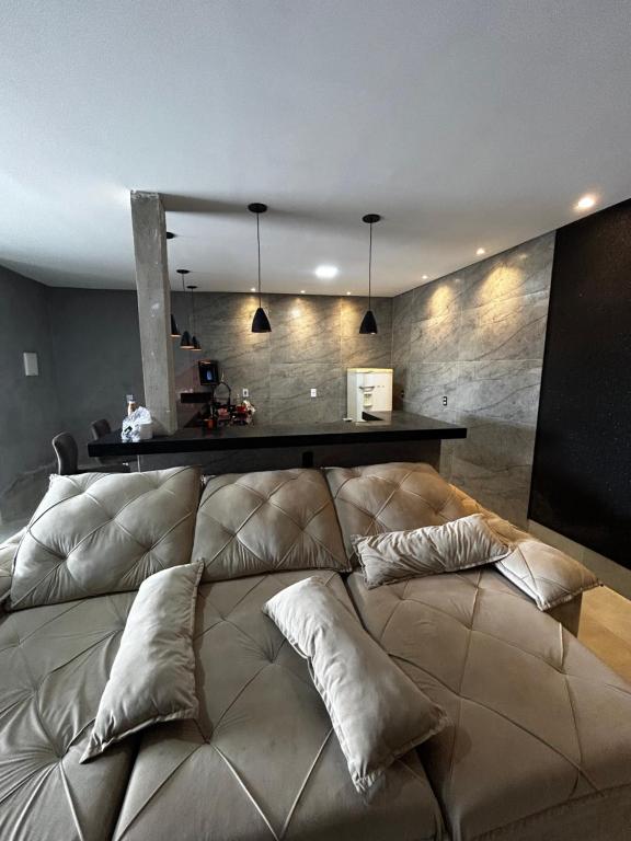 a large bed in a room with pillows on it at Sobrado Oliveira in Goiânia