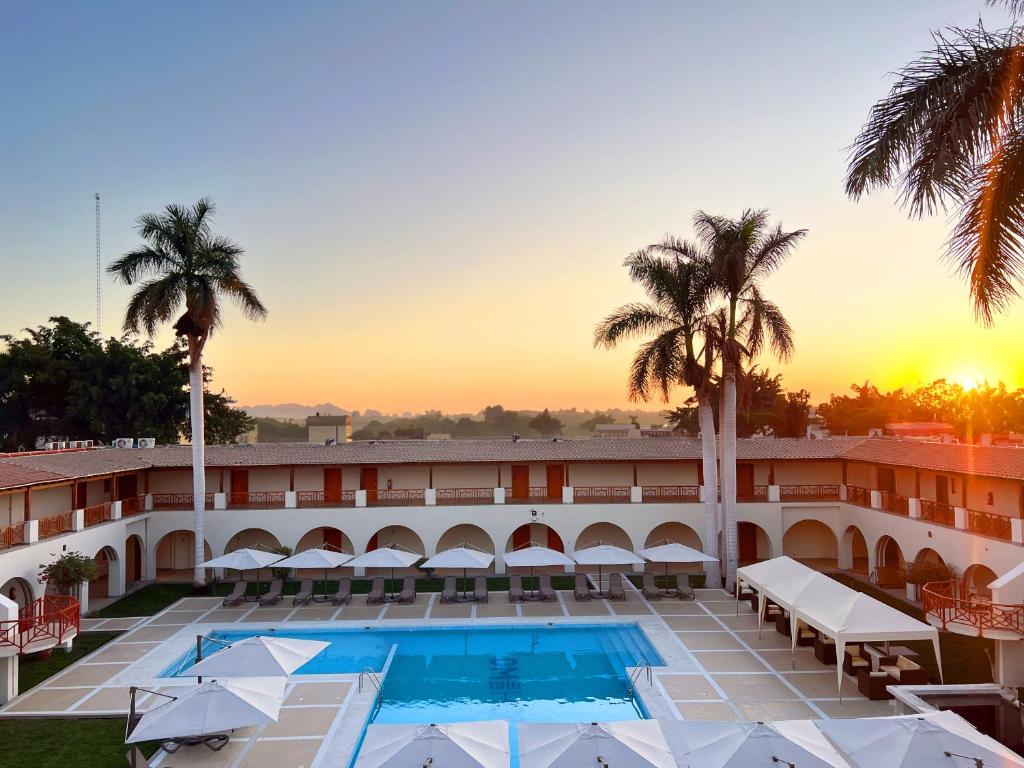 a hotel with a pool and palm trees at DM Hoteles Nasca in Nazca