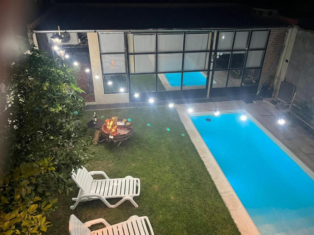 a backyard with a pool and chairs and a table and a fire pit at Quincho cervecero in San Fernando del Valle de Catamarca