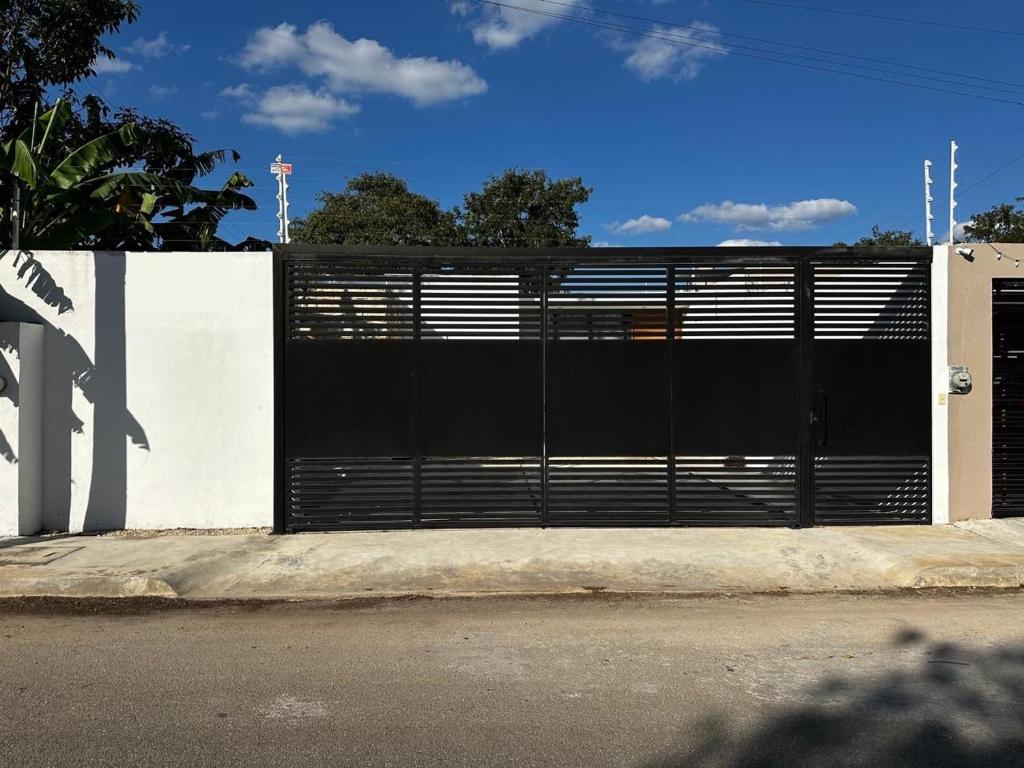 a black gate on the side of a building at Otoch de Paz in Cholul