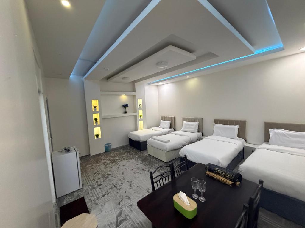 a hotel room with two beds and a table at SAMA Economic Apartment in Medina