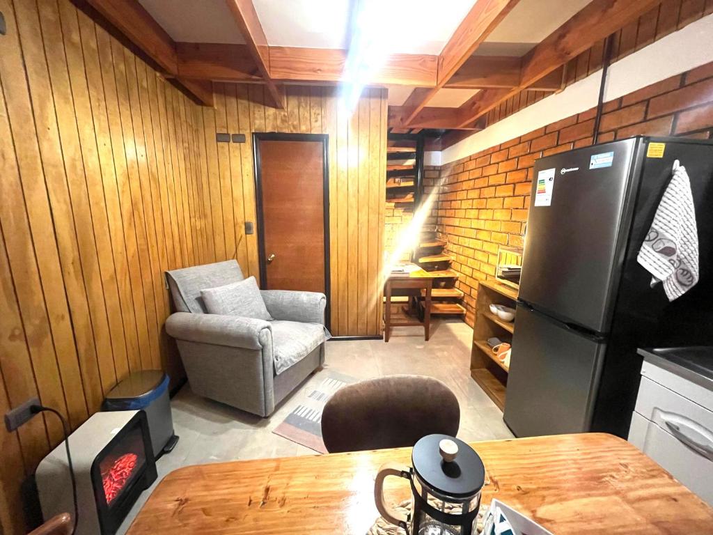a kitchen with a refrigerator and a chair and a table at Espacio Calma in Valdivia