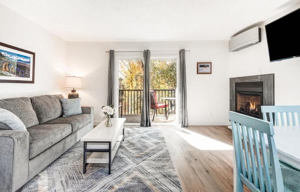 a living room with a couch and a fireplace at Modern Style Third Floor Condo with Private Balcony in Bend