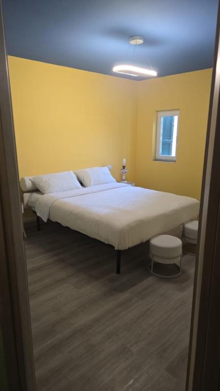 a bedroom with a large bed in a yellow room at Seravale in Serravalle