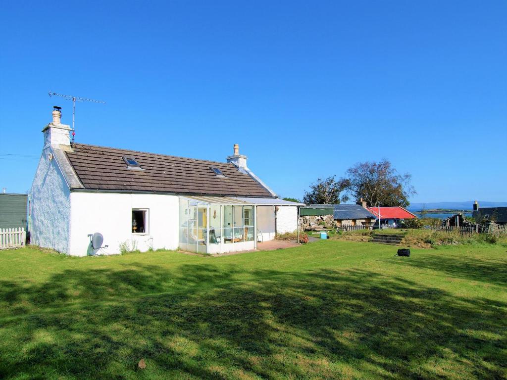 a white house in a field with a yard at Tigh Na Maraiche in Isle of Jura
