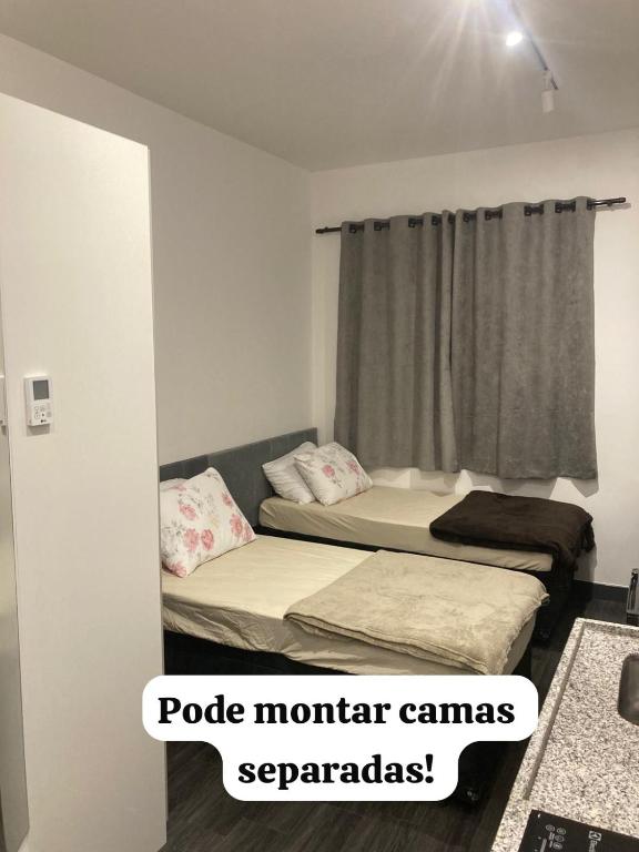 two beds in a room with the words pole montaram canvass sidx sidx at Studio 4 - São Caetano proximo GM in São Caetano do Sul