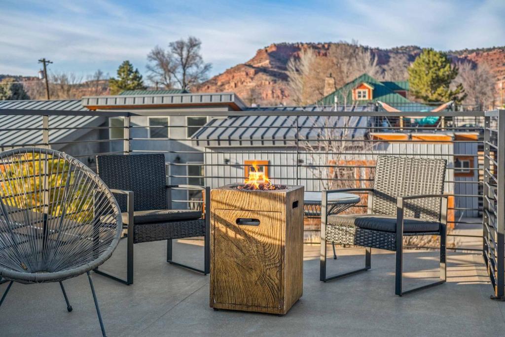 a patio with chairs and a table with a candle on it at Timber & Tin C 2Bed 2Bath w Pool & Rooftop Deck in Kanab