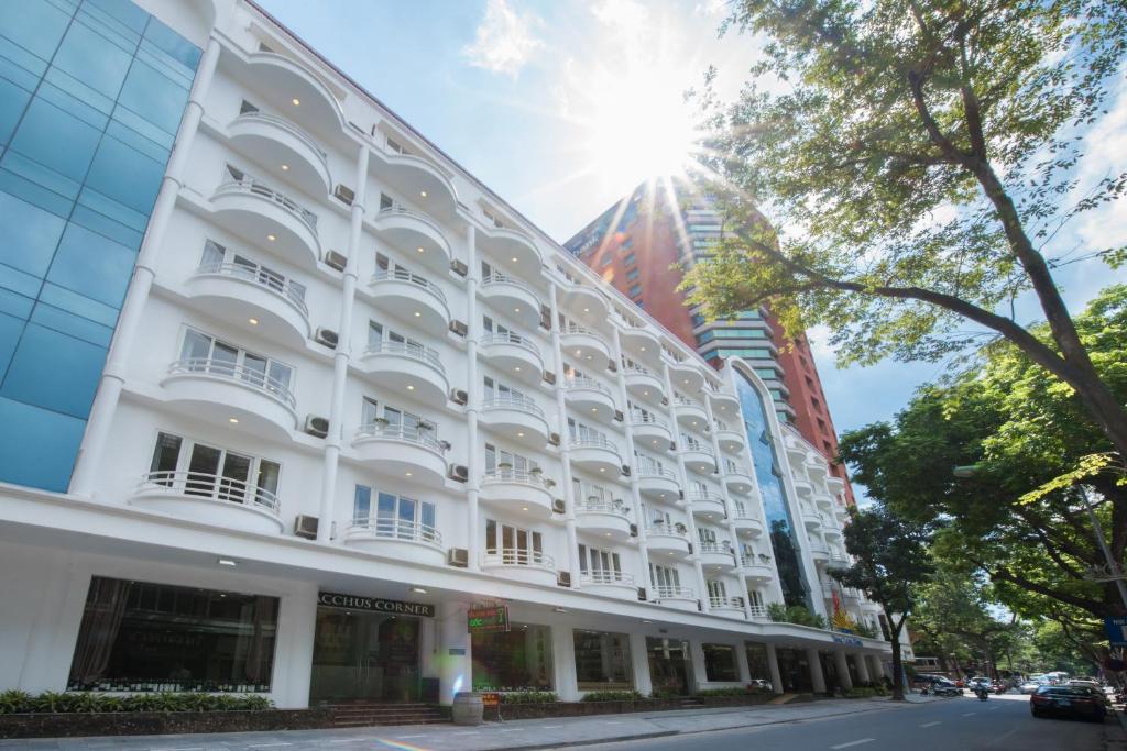 a white building on a street with buildings at Thang Long Opera Hotel in Hanoi