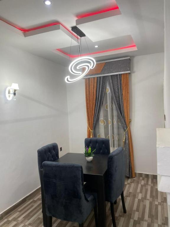a dining room with a table and two chairs at Knock inn luxury apartment in Benin City