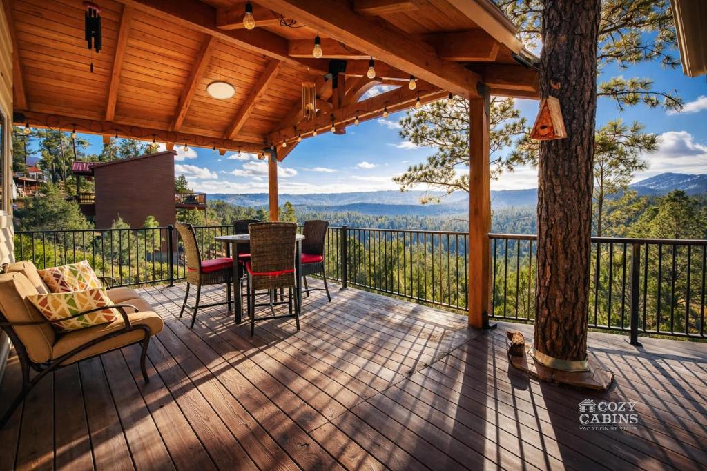 a screened porch with a table and chairs and a view at Montana Vista in Ruidoso