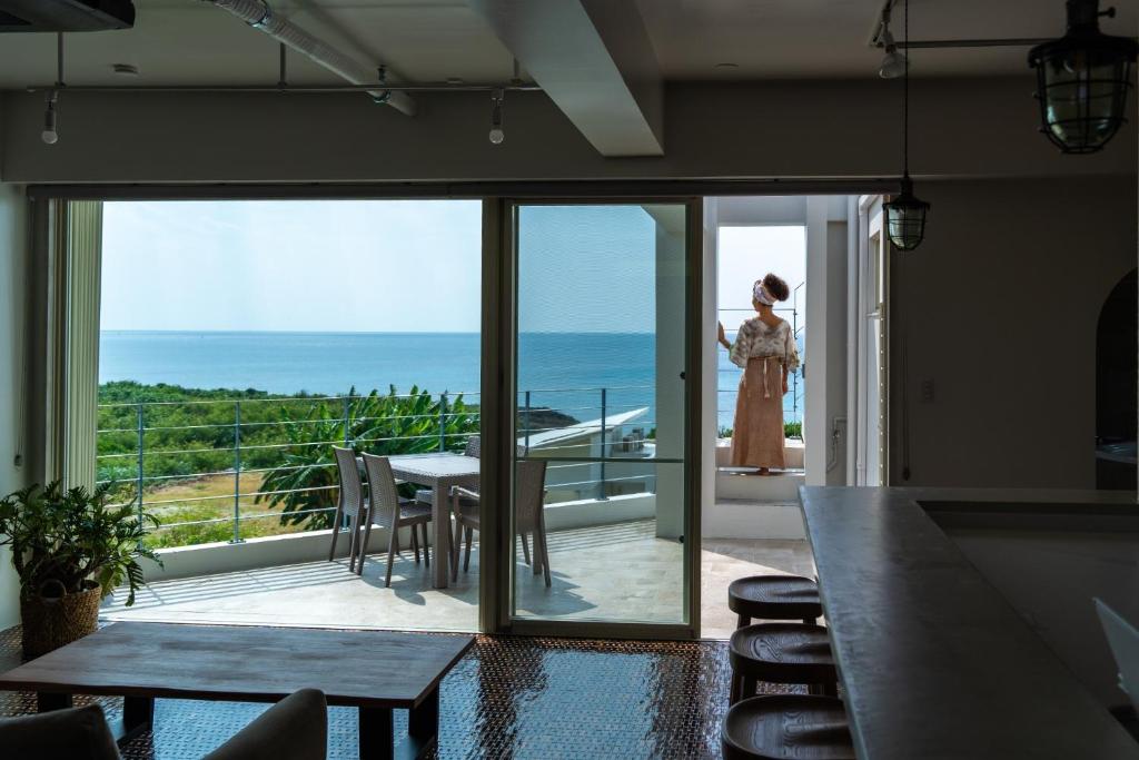 a woman standing on a balcony looking out at the ocean at DESLIE - Vacation STAY 74346v in Sarahama