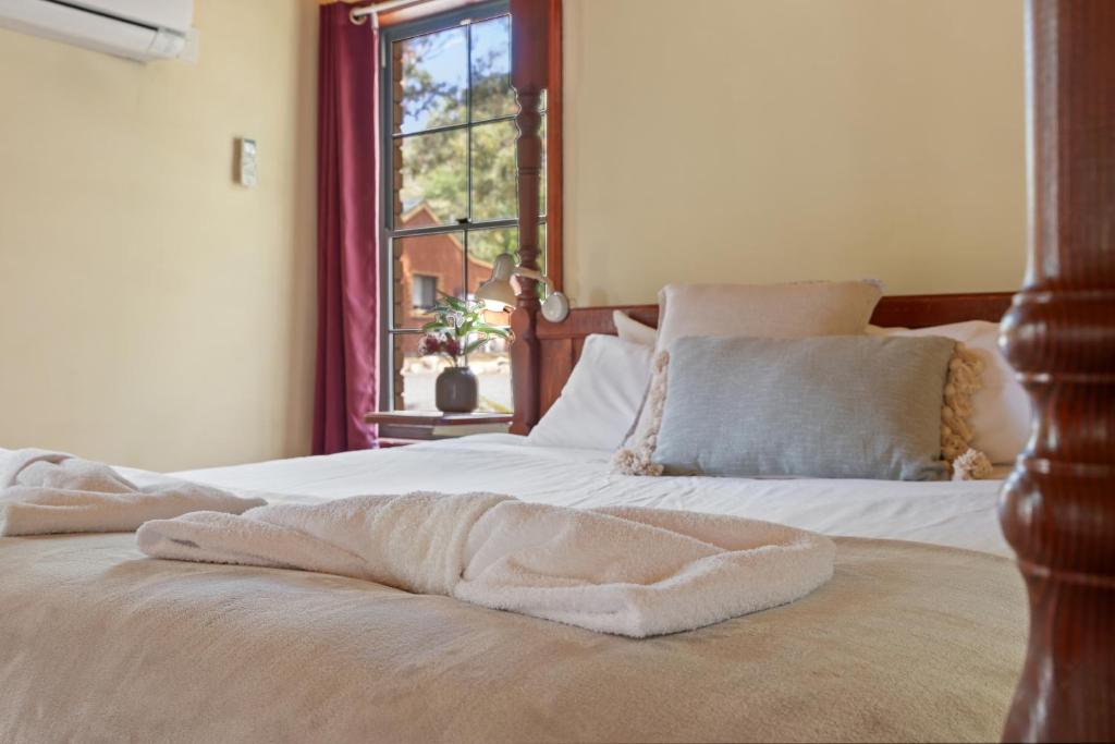 a bed with two towels on it with a window at Ironbark Villa 2 in Halls Gap