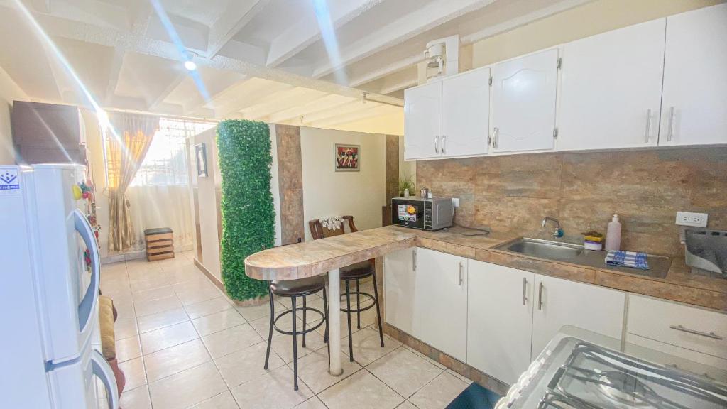 a kitchen with white cabinets and a counter top at SUITE AMOBLADA TODO INCLUIDO in Quito