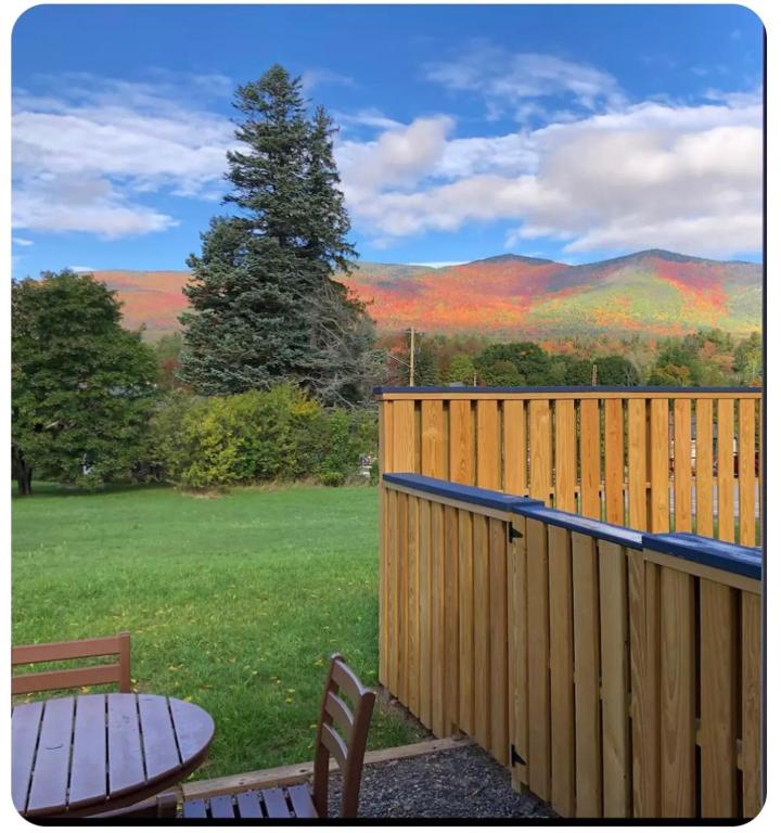a wooden deck with a table and a view of the mountains at Mountain View Cottage in Wilmington