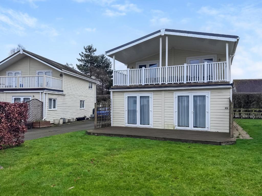 a house with a balcony on top of a yard at Royal Retreat in Wisbech