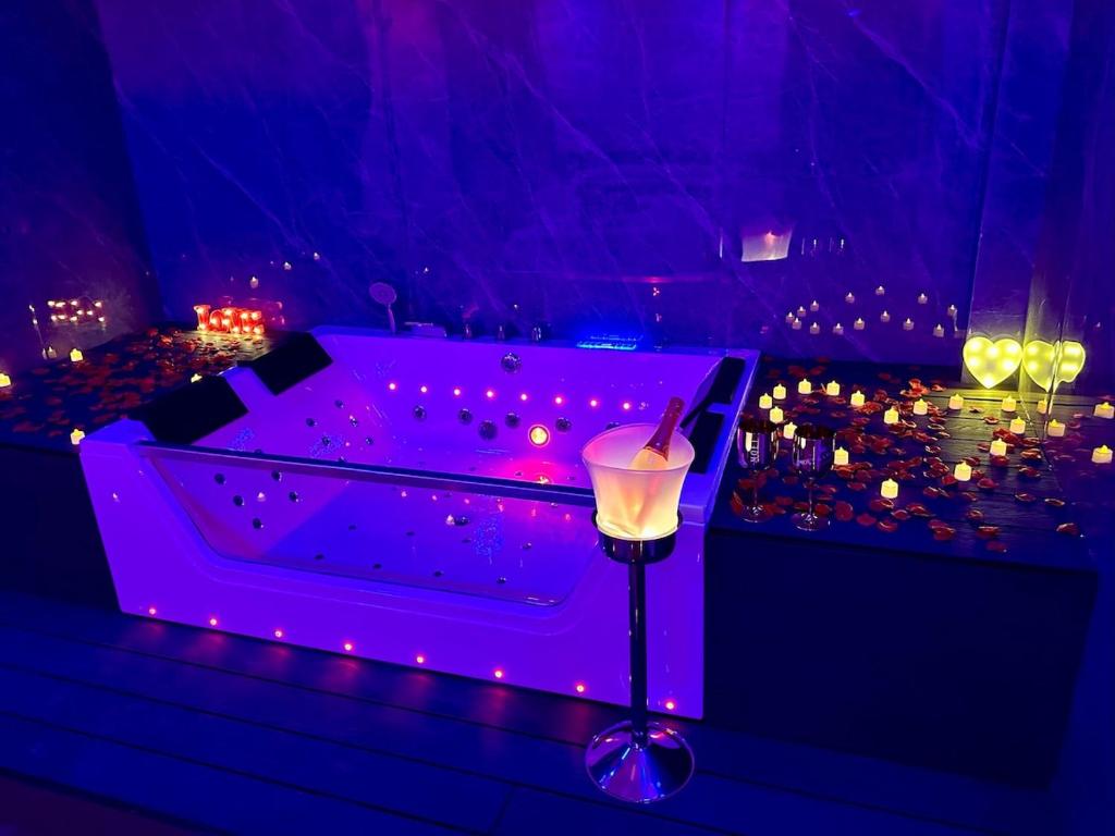 a purple room with a tub with a candle at Cazalegas Sky Spa in Cazalegas
