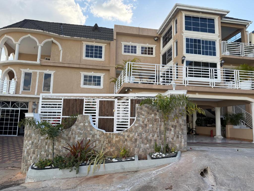 a large house with a stone fence in front of it at 1 BR Love Cube in Kingston
