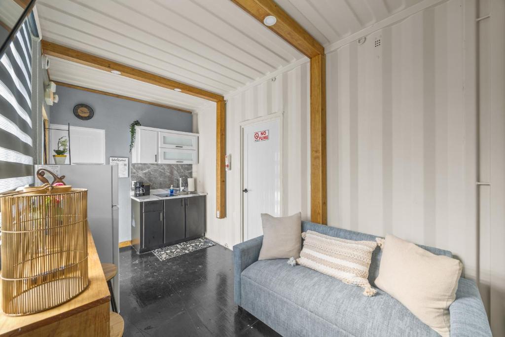 a living room with a blue couch and a kitchen at Cozy 1BR Beachside Apartment Entre Olas in Vega Baja