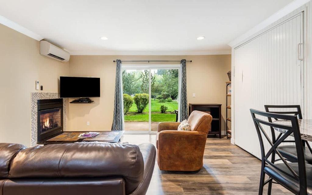 a living room with a leather couch and a chair at First-Floor Downtown Bend Condo in Bend