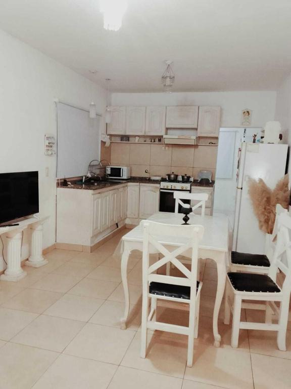 a kitchen with a white table and a refrigerator at Casa Sofía in Paraná