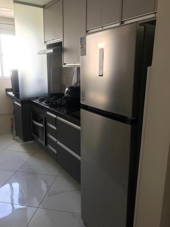 a kitchen with a stainless steel refrigerator and a stove at Apto completo próximo a Johnson e Johnson e Dutra in São José dos Campos
