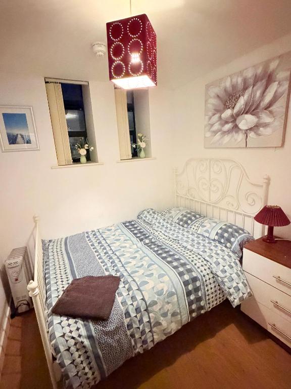 a bedroom with a bed and a chandelier at Quick Stop Double Bed Flat - Bradford City Center in Bradford