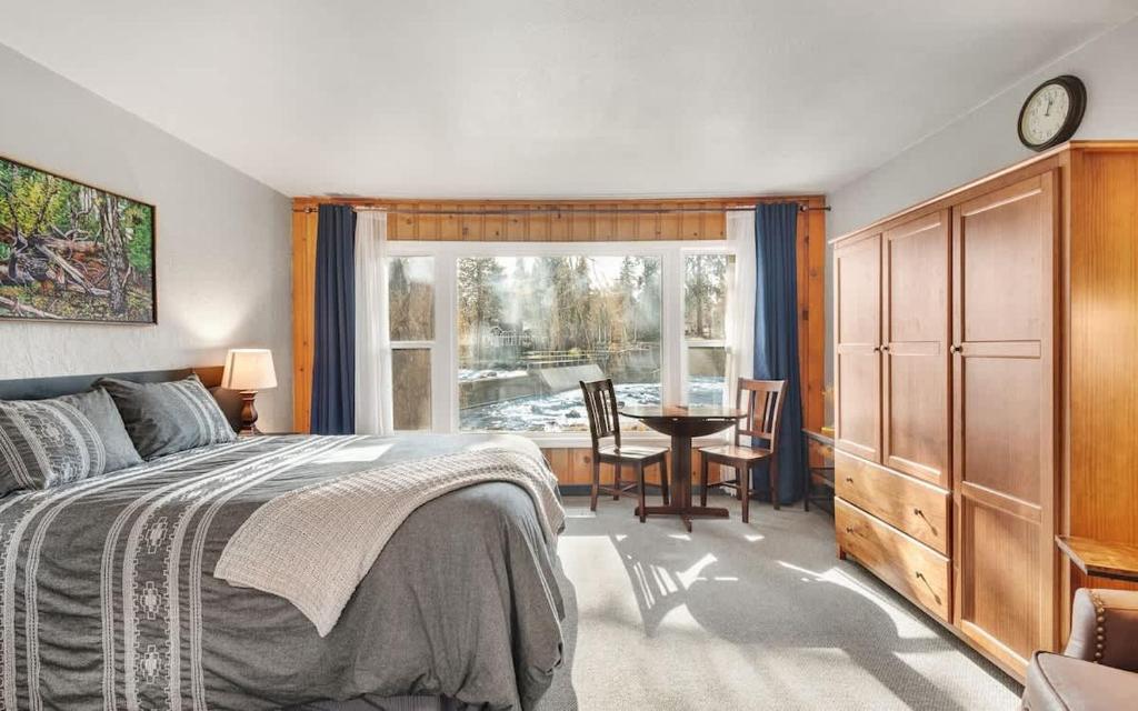 a bedroom with a bed and a table and a window at Riverfront Studio with Trail access in Bend