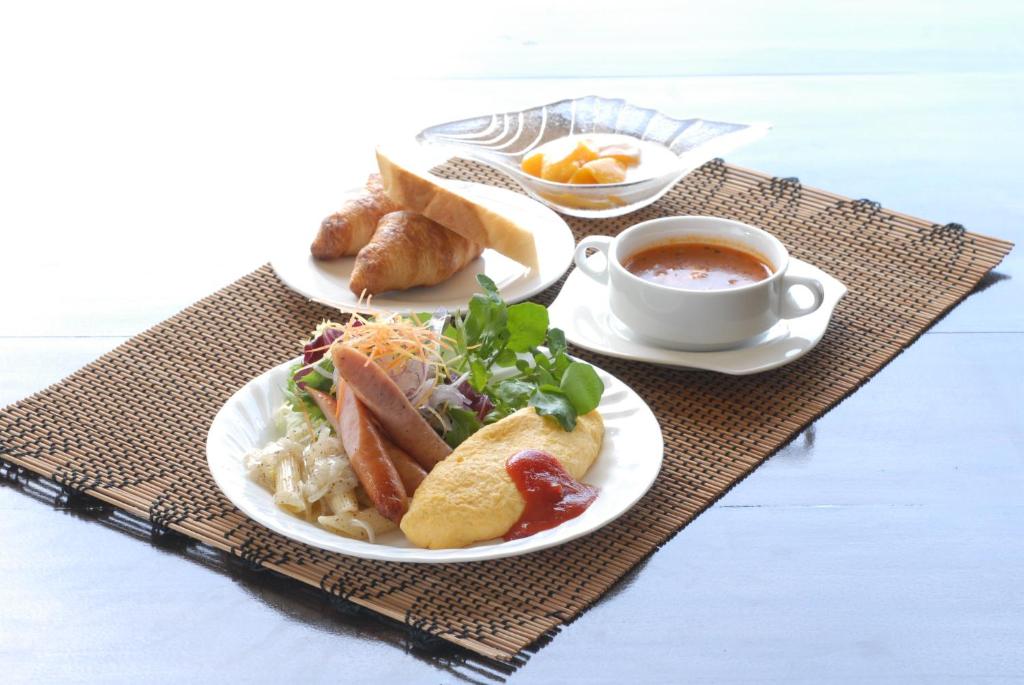 a table with two plates of food and a cup of coffee at Kerama Terrace in Tokashiki
