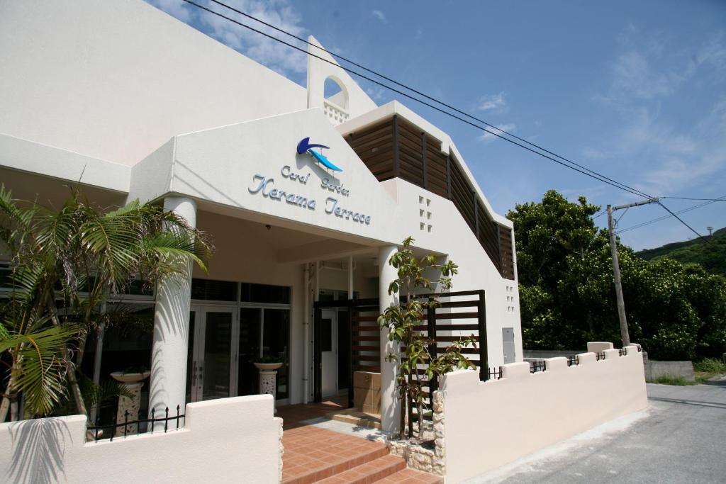 a white building with a sign on it at Kerama Terrace in Tokashiki