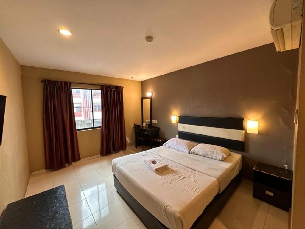 a bedroom with a large bed and a window at Swing & Pillows - Skudai Johor in Skudai