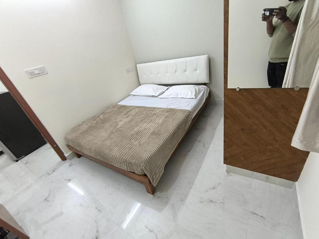 a man taking a picture of a bed in a room at BroFlats in Bangalore